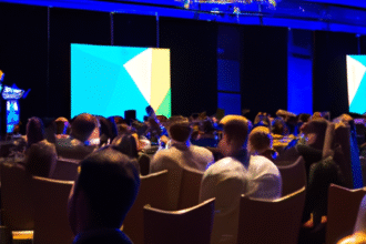 J.D. Vance speaks on Bitcoin adoption at a conference, with an engaged audience and digital currency visuals.